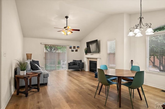4315 Outlook Blvd Unit L, Pueblo, CO 81008 - dining space featuring vaulted ceiling, a tile fireplace, wood finished floors, baseboards, and ceiling fan
