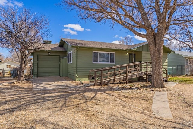 ranch-style house featuring an attached garage, a shingled roof, fence, a deck, and driveway