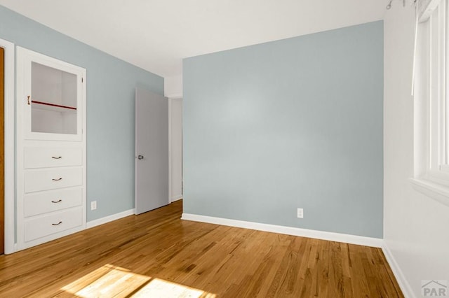 unfurnished bedroom featuring light wood-style flooring and baseboards