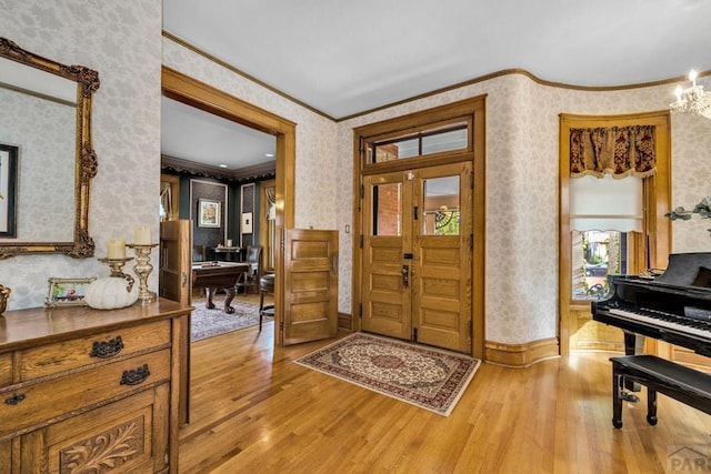 326 W Pitkin Ave, Pueblo, CO 81004 - entryway featuring wallpapered walls, ornamental molding, light wood-style flooring, a chandelier, and baseboards