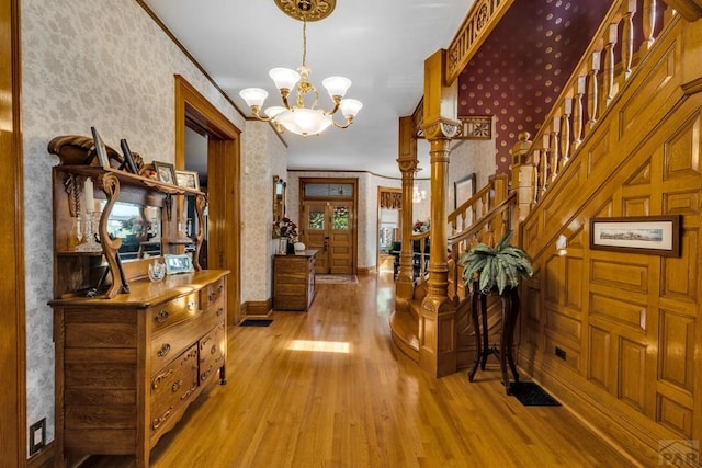 326 W Pitkin Ave, Pueblo, CO 81004 - foyer entrance with wallpapered walls, wood finished floors, a chandelier, stairway, and baseboards