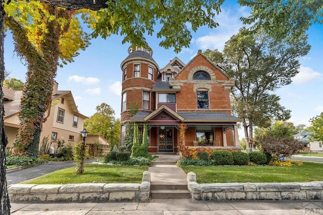 326 W Pitkin Ave, Pueblo, CO 81004 - victorian-style house featuring brick siding, a porch, and a front yard