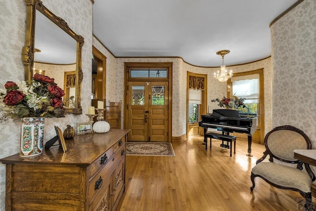 326 W Pitkin Ave, Pueblo, CO 81004 - foyer entrance with wallpapered walls, wood finished floors, healthy amount of natural light, a chandelier, and ornamental molding