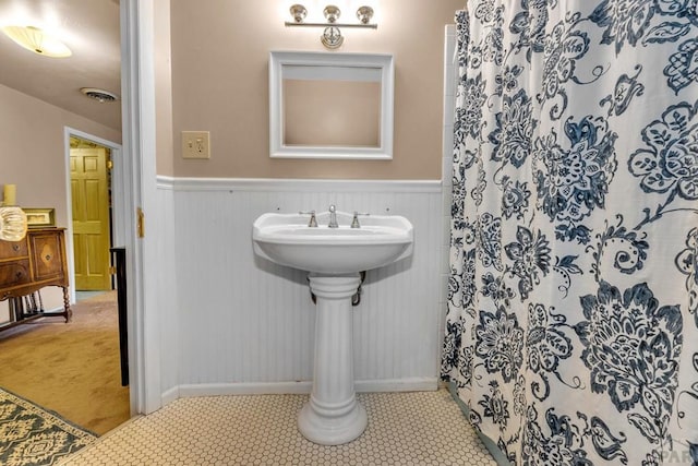 326 W Pitkin Ave, Pueblo, CO 81004 - bathroom with wainscoting, a shower with curtain, and baseboards