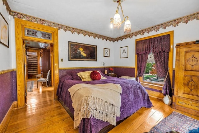 326 W Pitkin Ave, Pueblo, CO 81004 - bedroom featuring wood-type flooring, a chandelier, and a wainscoted wall