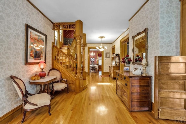 326 W Pitkin Ave, Pueblo, CO 81004 - hall with wallpapered walls, stairs, light wood-style flooring, a chandelier, and ornamental molding