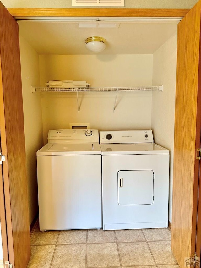 laundry room featuring light tile patterned floors and washing machine and clothes dryer