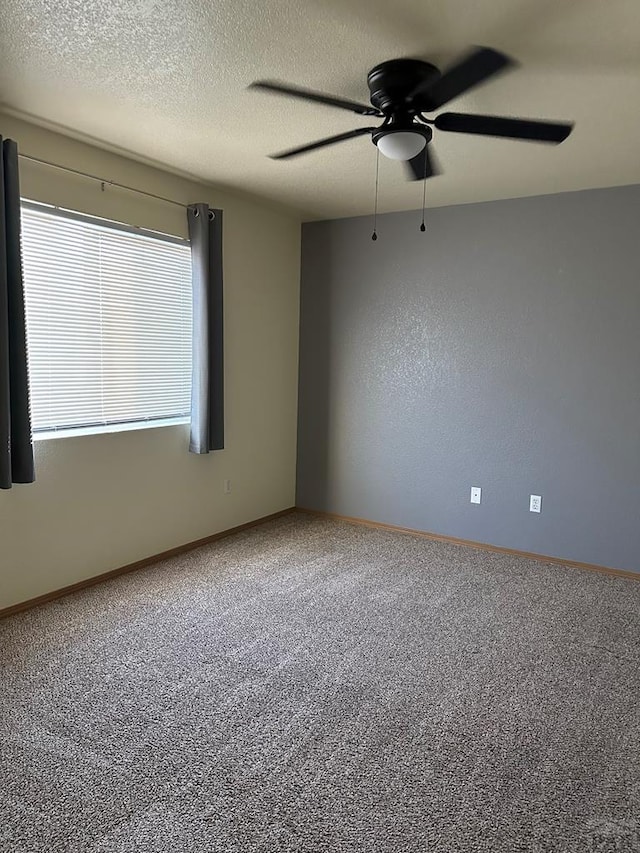 spare room featuring a ceiling fan, carpet floors, a textured ceiling, and baseboards