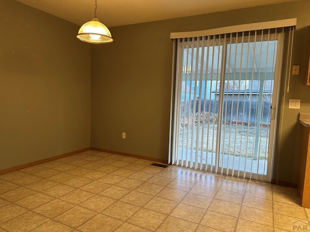 unfurnished room featuring light floors, a wealth of natural light, and baseboards