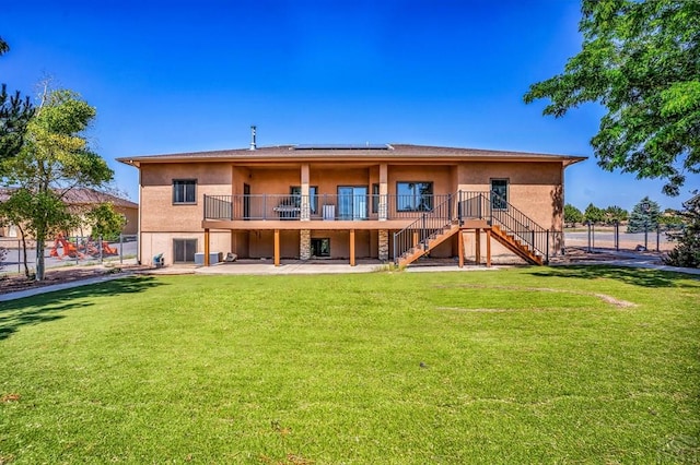 368 S Camino De Los Ranchos, Pueblo West, CO 81007 - back of house with stairs, stucco siding, roof mounted solar panels, and a wooden deck