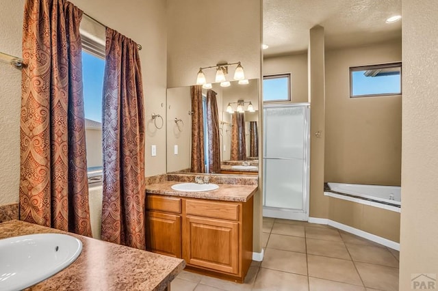 368 S Camino De Los Ranchos, Pueblo West, CO 81007 - bathroom with tile patterned flooring, vanity, a relaxing tiled tub, and a textured ceiling