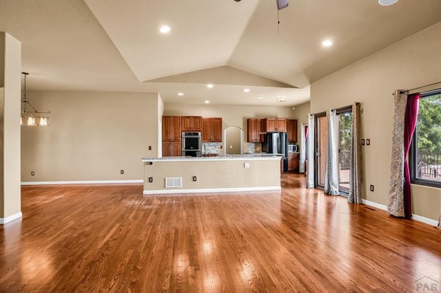 368 S Camino De Los Ranchos, Pueblo West, CO 81007 - unfurnished living room featuring vaulted ceiling, light wood-style flooring, a ceiling fan, recessed lighting, and a chandelier