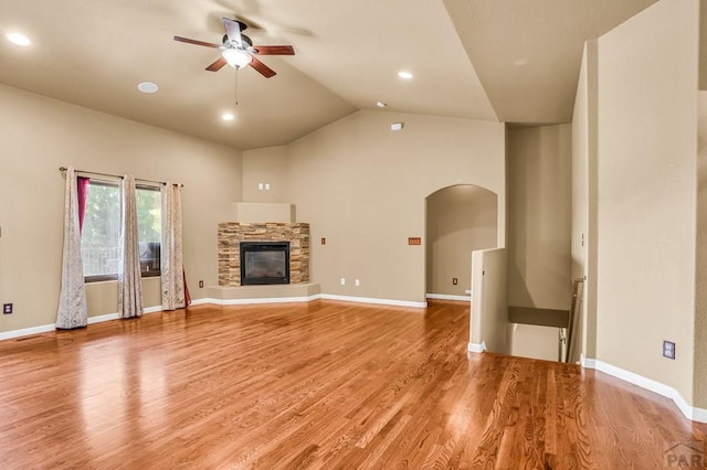 368 S Camino De Los Ranchos, Pueblo West, CO 81007 - unfurnished living room with a ceiling fan, arched walkways, lofted ceiling, light wood-type flooring, and a fireplace