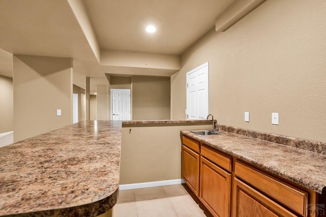 368 S Camino De Los Ranchos, Pueblo West, CO 81007 - kitchen with brown cabinetry, a peninsula, and light tile patterned floors