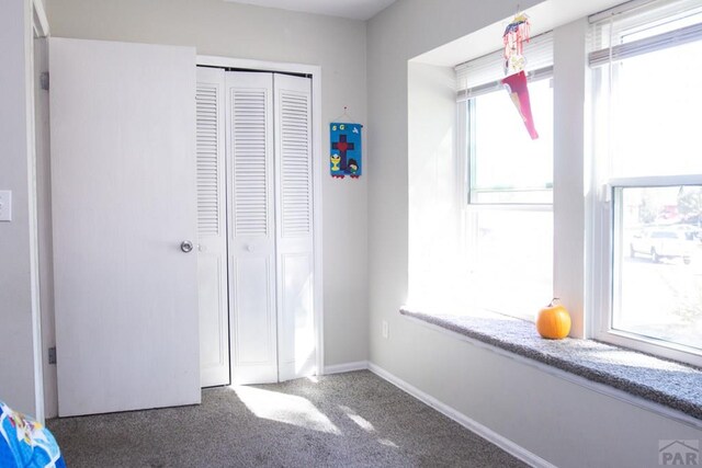 unfurnished bedroom featuring a closet, carpet, and baseboards