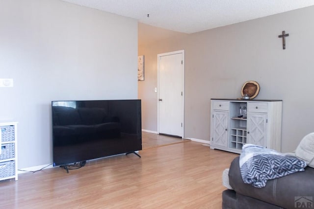 sitting room featuring vaulted ceiling, wood finished floors, and baseboards