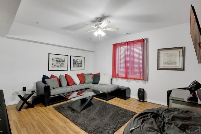 living room featuring visible vents, wood finished floors, a ceiling fan, and baseboards