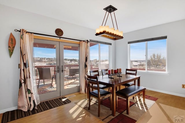 dining room featuring french doors, light wood-style flooring, and baseboards