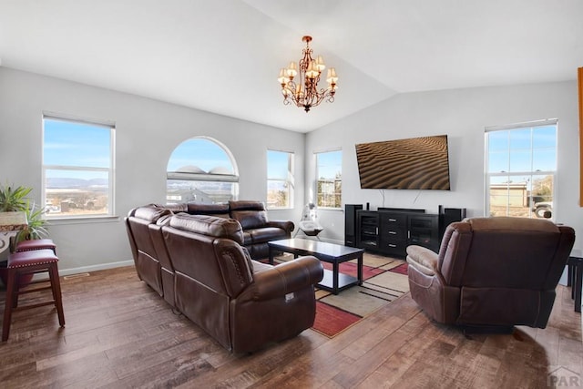 living area with a healthy amount of sunlight, an inviting chandelier, vaulted ceiling, and wood finished floors