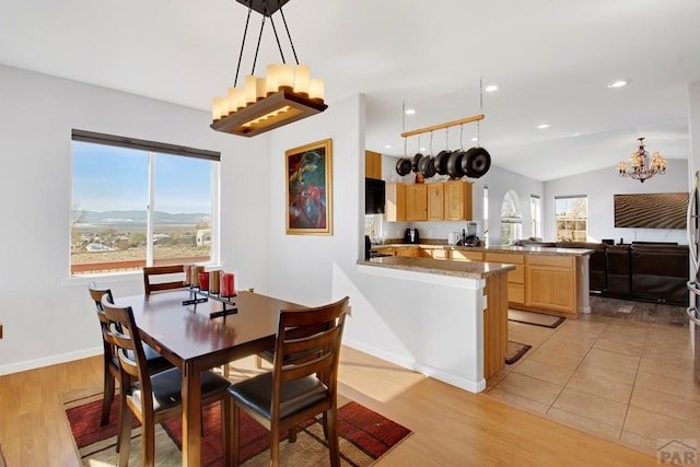 dining space with a healthy amount of sunlight, light wood-style flooring, and lofted ceiling