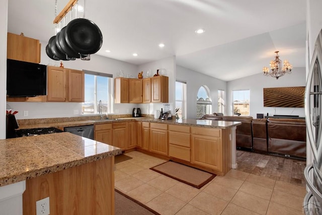 kitchen featuring tile countertops, a peninsula, a sink, appliances with stainless steel finishes, and decorative light fixtures