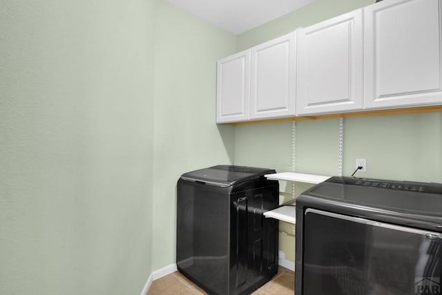 laundry area with cabinet space, baseboards, and light tile patterned floors