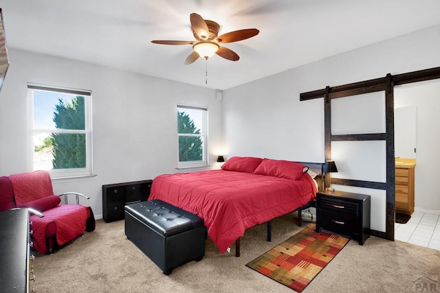 bedroom featuring carpet, connected bathroom, baseboards, and a barn door