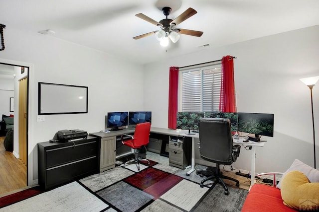 home office with a ceiling fan, visible vents, light wood-style floors, and baseboards