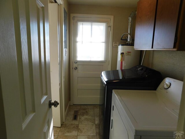 clothes washing area with cabinet space, visible vents, electric water heater, light tile patterned flooring, and washer and dryer