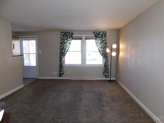 spare room featuring carpet, baseboards, and a baseboard radiator