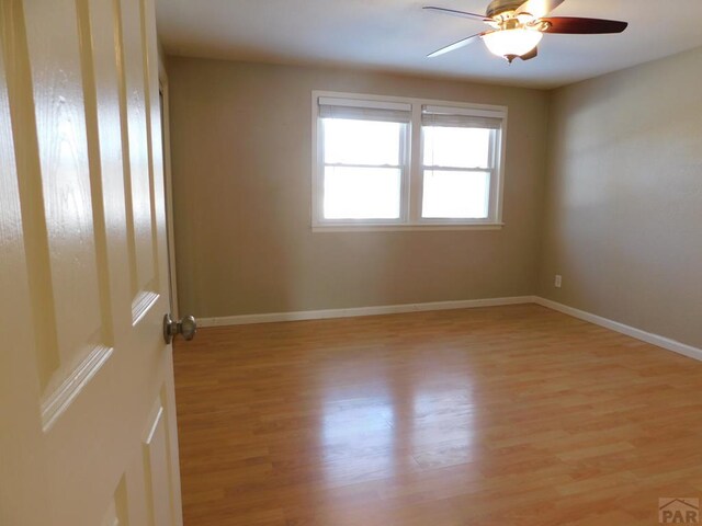 unfurnished room featuring light wood-style flooring, baseboards, and a ceiling fan