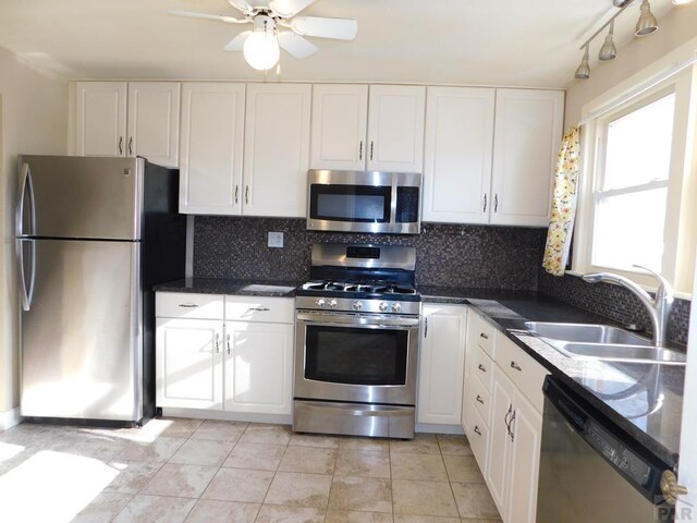 kitchen featuring ceiling fan, a sink, white cabinets, appliances with stainless steel finishes, and backsplash