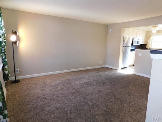 unfurnished living room featuring a ceiling fan, carpet flooring, and baseboards