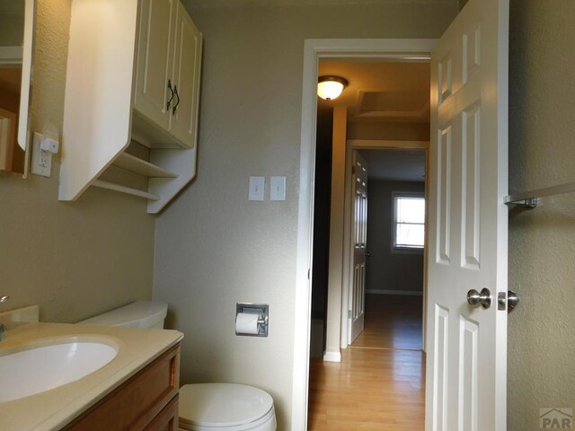 bathroom featuring toilet, wood finished floors, and vanity