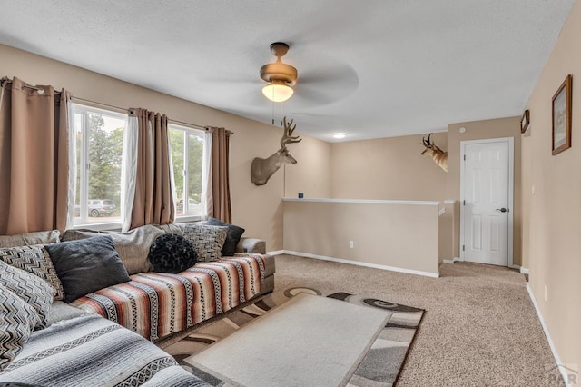 living room featuring ceiling fan, carpet, and baseboards