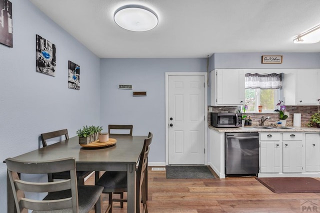 kitchen featuring stainless steel appliances, white cabinets, and light countertops