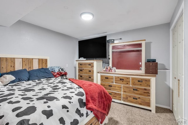 carpeted bedroom with baseboards and a closet