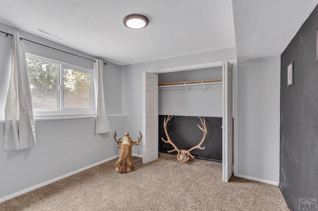 carpeted bedroom featuring visible vents, baseboards, and a closet