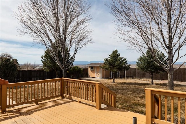 deck featuring an outbuilding, a fenced backyard, and a shed