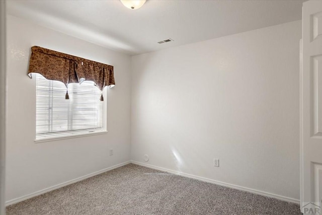 carpeted empty room with visible vents and baseboards