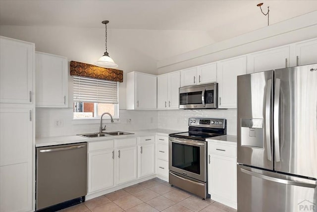 kitchen featuring vaulted ceiling, stainless steel appliances, light countertops, and a sink