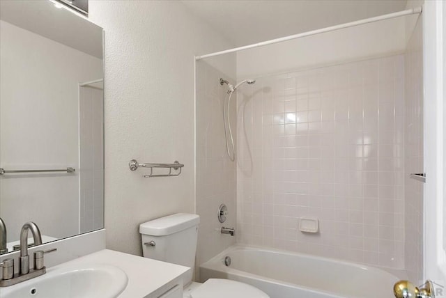 bathroom with vanity, toilet, bathing tub / shower combination, and a textured wall