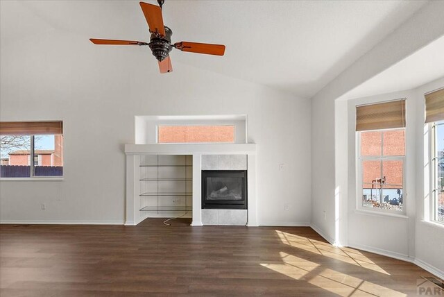 unfurnished living room with a glass covered fireplace, lofted ceiling, and wood finished floors