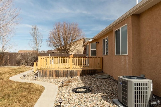 view of yard with central AC, a deck, and fence