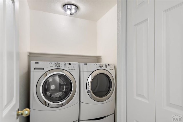 laundry room featuring laundry area, independent washer and dryer, and a textured ceiling