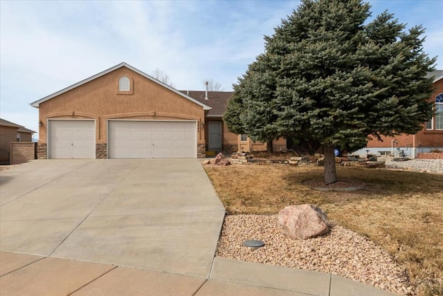 view of front of home featuring a garage, stone siding, concrete driveway, and stucco siding