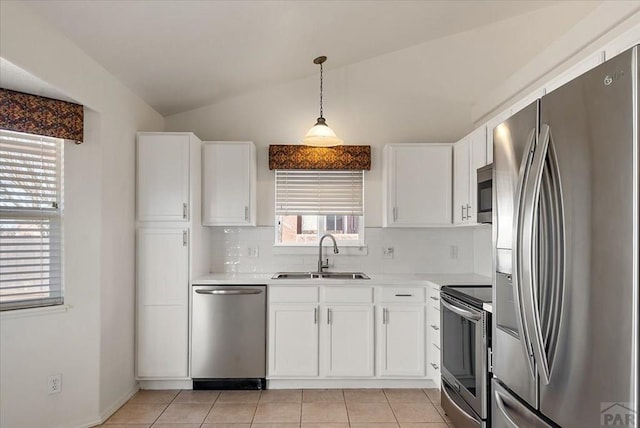 kitchen with a sink, lofted ceiling, appliances with stainless steel finishes, and light countertops