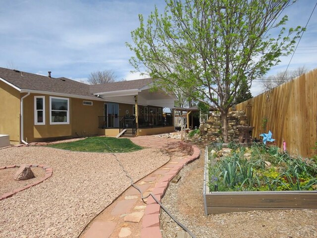 back of property featuring a patio area, a shingled roof, fence, and stucco siding