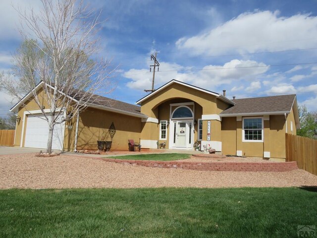 ranch-style house with stucco siding, a front yard, fence, a garage, and driveway