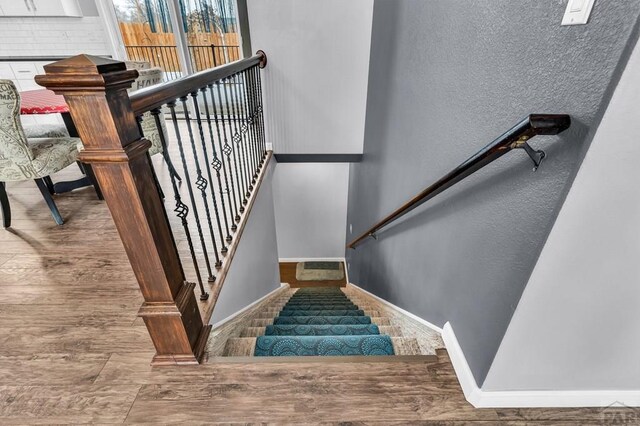 stairway featuring wood finished floors and baseboards